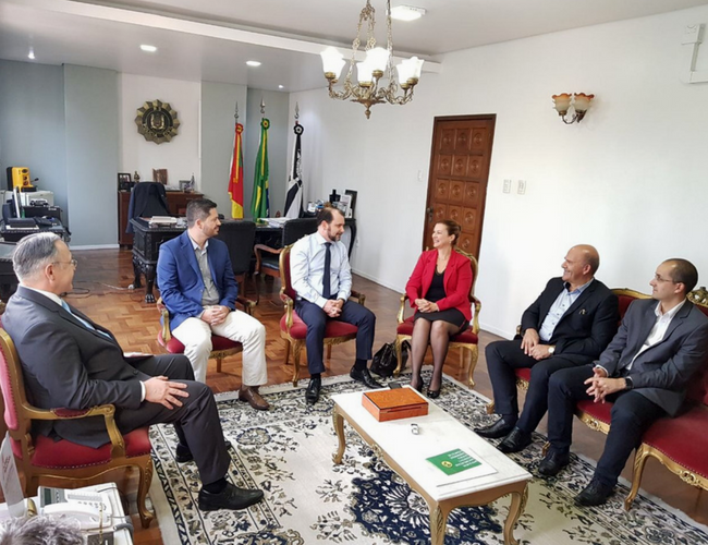 Prefeita Fátima e autoridades sentadas em uma sala no entorno de uma mesa
