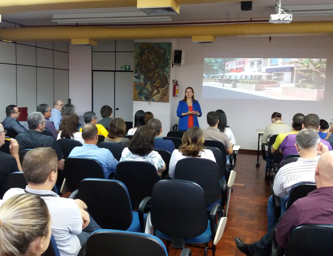 Em pé, a prefeita Fátima fala para uma platéia sentada