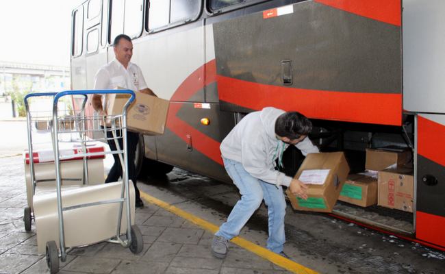 Homem colocando uma carga no ônibus