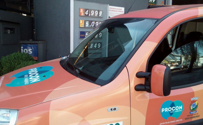 Carro adesivado do Procon parado em um posto de gasolina