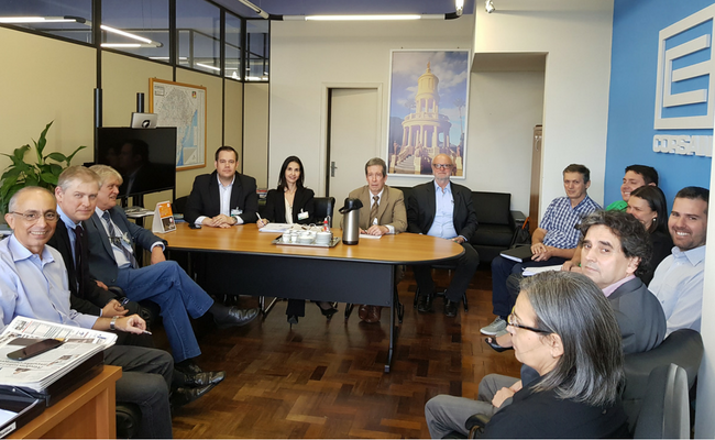 Representantes da Corsan e Comusa sentando ao redor de uma mesa