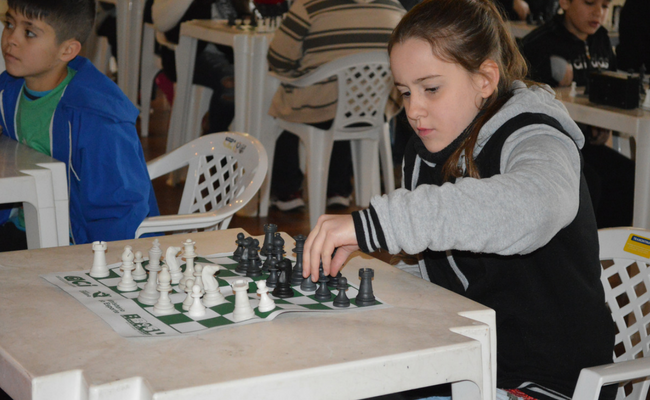 Menina sentada jogando xadrez