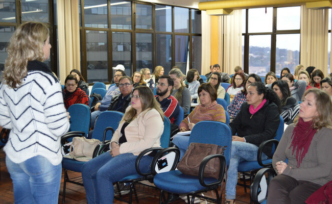 Palestrante em pé e platéia sentada em um auditório