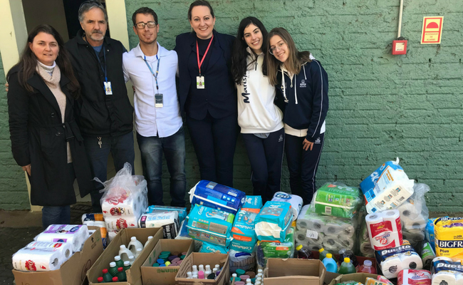 Produtos doados ao chão e equipes do Marista e Hospital em pé
