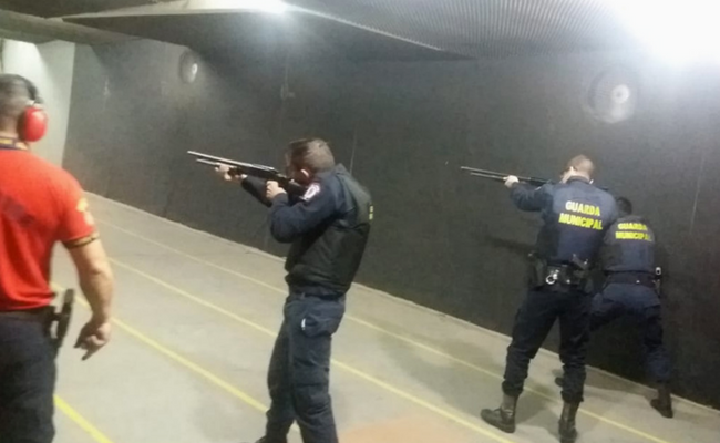 Homem em pé com armas na mão mirando um alvo