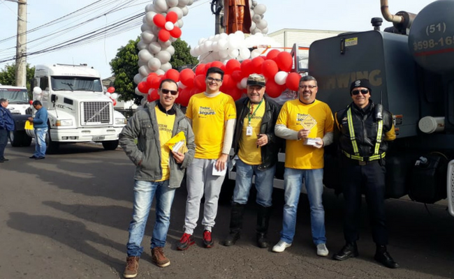Quatro pessoas em pé com os adesivos nas mãos