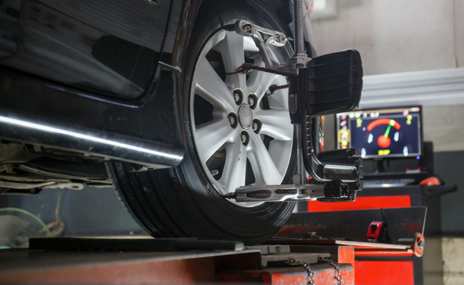 Roda de um carro preto içado com uma ferramenta no aro