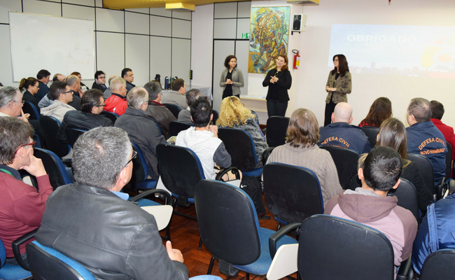 Rebeca, Fátima e Roberta em pé e platéia sentada