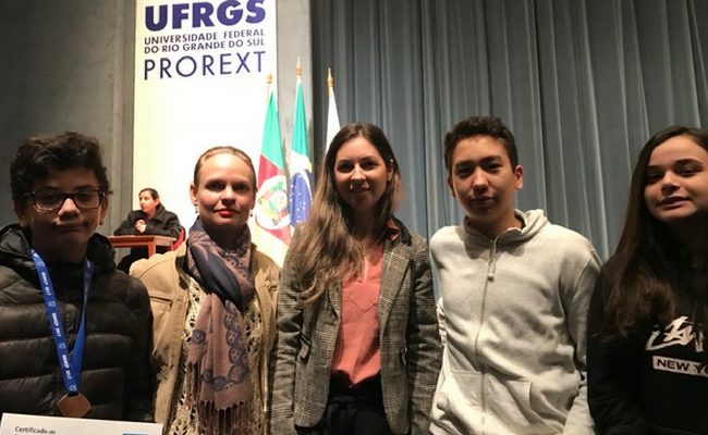 Alunos e professsora em pé com o certificado