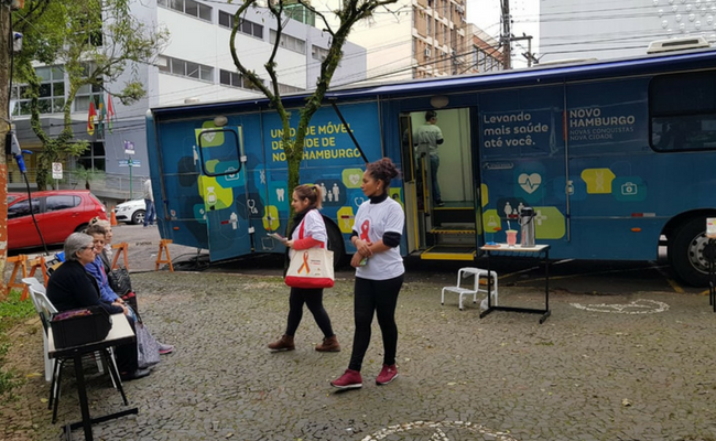 Ônibus estacionado com duas enfermeiras na frente