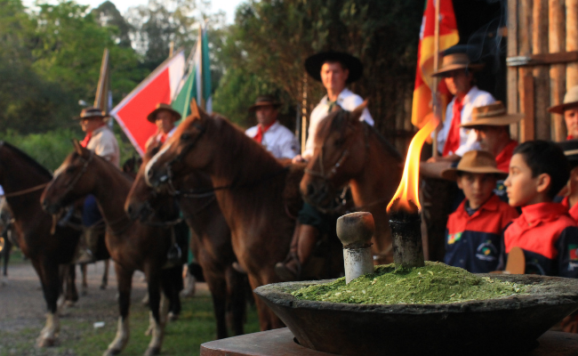 Chama em um primeiro plano e cavalheiros desfocados ao fundo