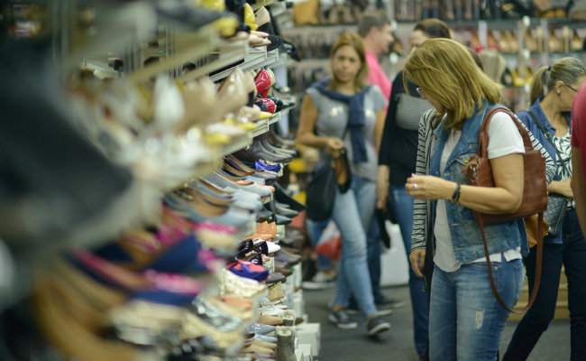 Uma mulher olhar uma estande de sapatos
