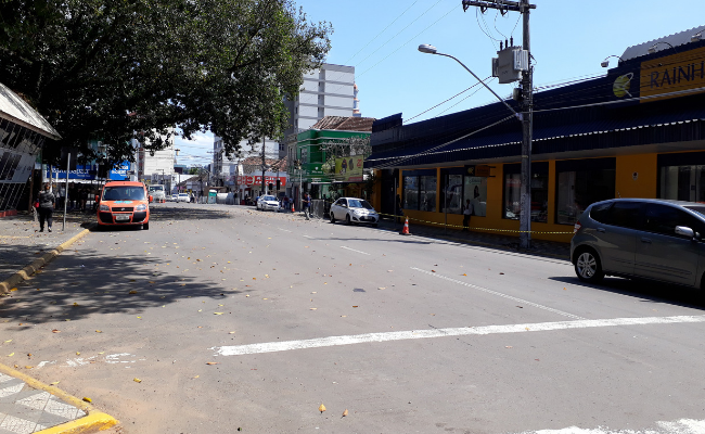 Rua de asfalto com lojas do lado direito