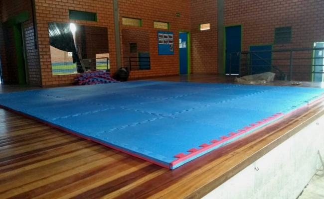 Em uma sala, o tatame azul no chão