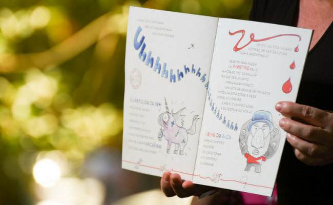 Uma mulher segura um livro infantil aberto nas mãos