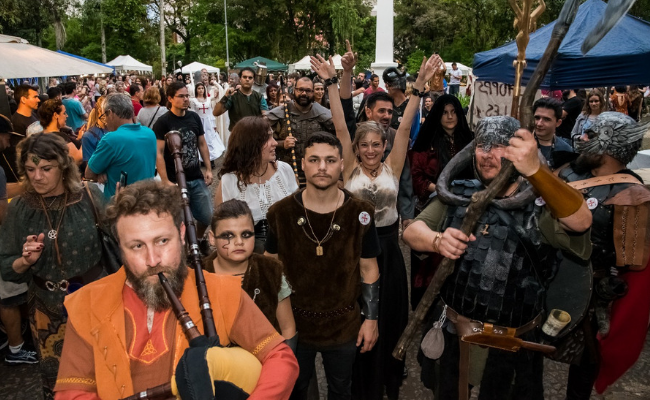 Na praça, homens vestidos com roupas medievais