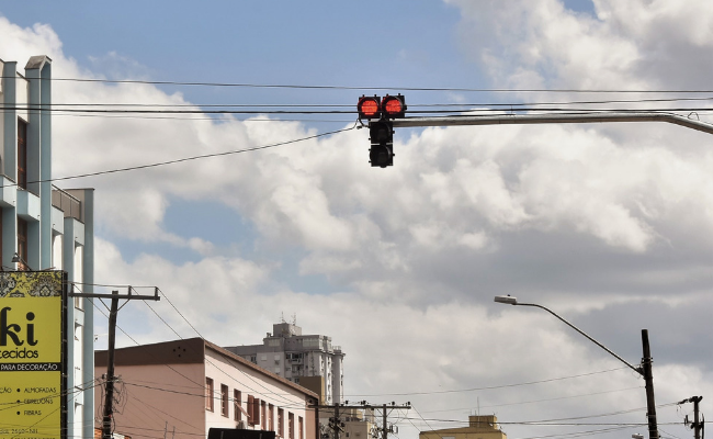 Uma sinaleira suspensa com a luz vermelha acessa