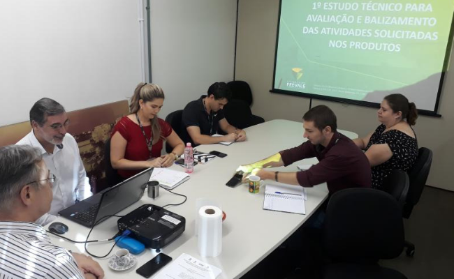 Mesa ao centro, com pessoas sentadas no entorno