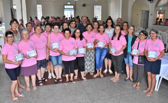 Grupo de mulheres em pé com o livro nas mãos