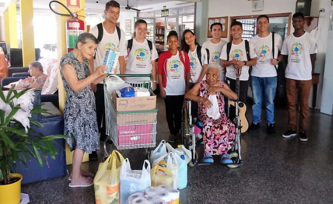 Com os produtos na frente, jovens e idosos posam para a foto