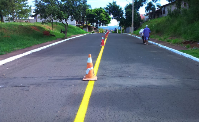 Uma rua com a sinalização central pintada de amarelo