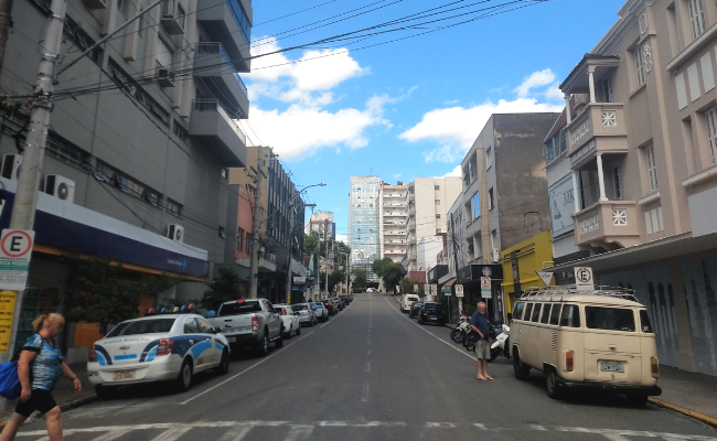 Uma rua com carros estacionados dos dois lados