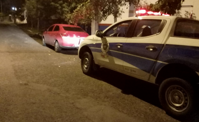 Uma caminhonete e um carro parados em uma rua semiescura