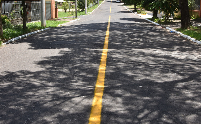 Imagem de uma rua asfaltada com uma linha amarela pintada no centro