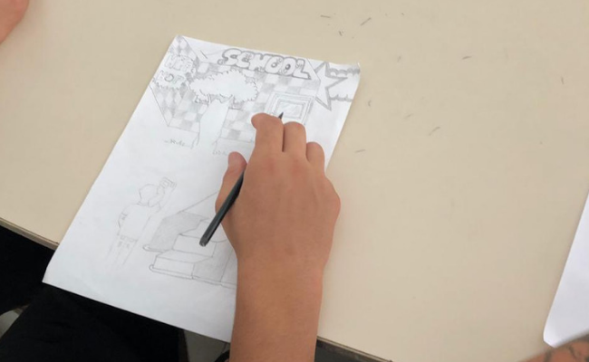 Uma mão segurando um lápis faz um desenho em um papel em branco