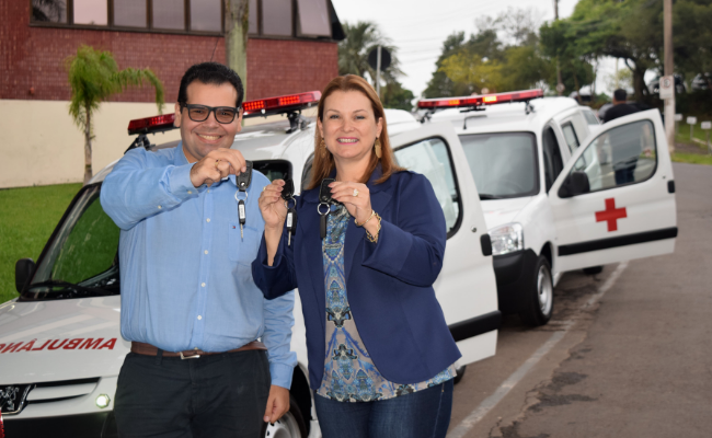 Naasom Luciano e a prefeita Fátima seguram uma chave, com as ambulâncias estacionadas em suas costas