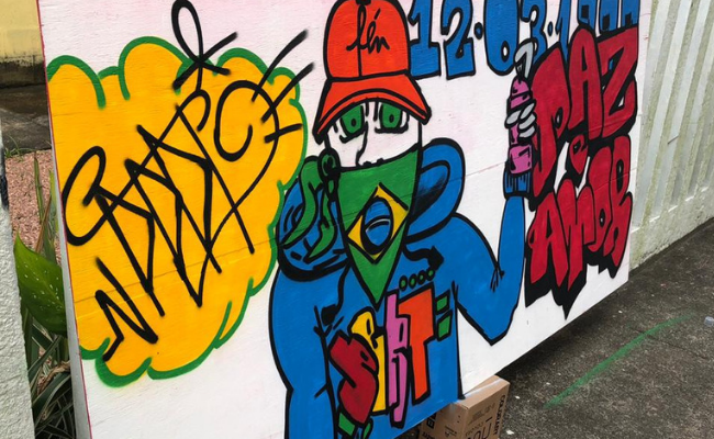 Um painel com um desenho escorado em um muro