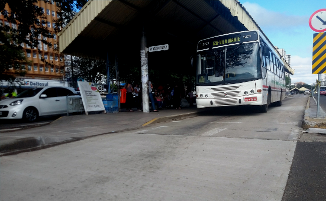 Em uma parada de ônibus, veículo estaciona para pegar os passageiros