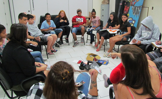 Grupo de jovens sentados em circúlo em um sala