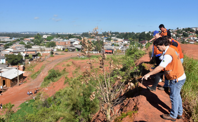Em cima de um morro, cinco pessoas olhando para baixo