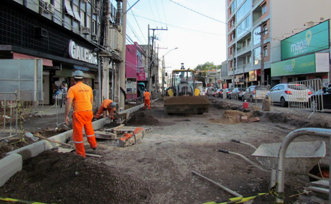 Rua em obras com homens trabalhando