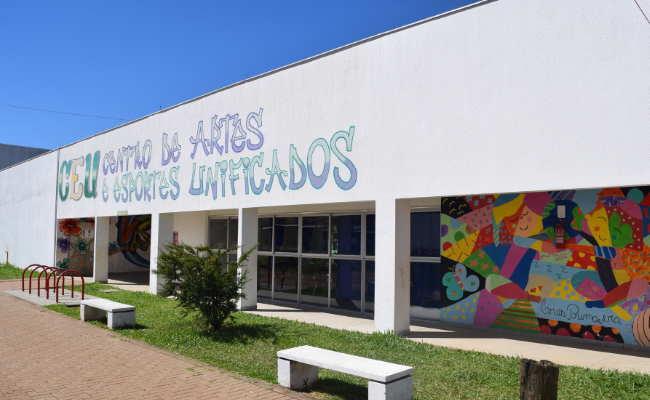 Prédio branco com o escrito Centro de Artes e Esportes Unificados 