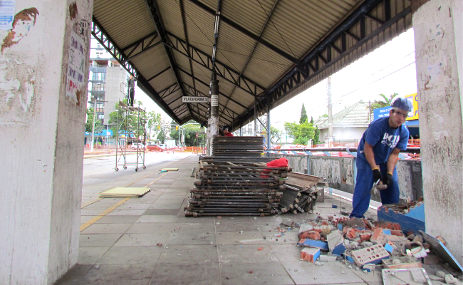 No Paradão, que é uma grande parada de ônibus, funcionário quebra o concreto com uma marreta