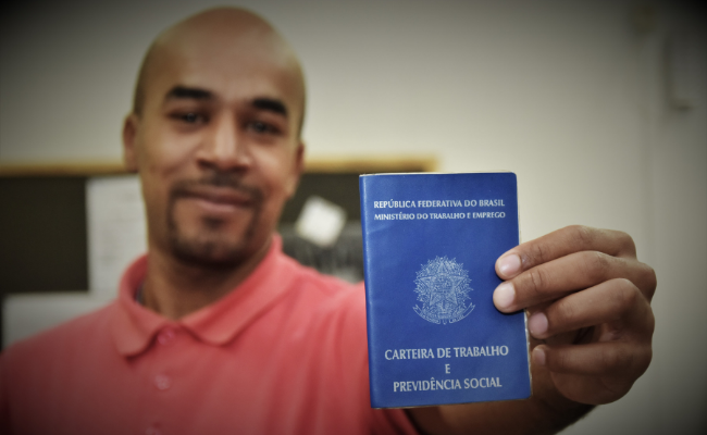 Homem segurando uma carteira de trabalho