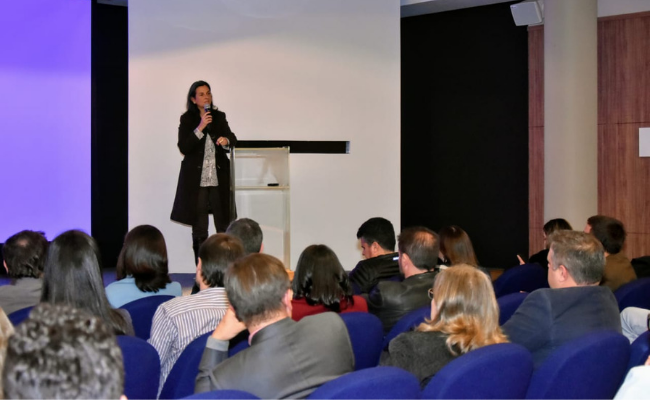 Secretária Paraskevi em pé ao microfone em um palco