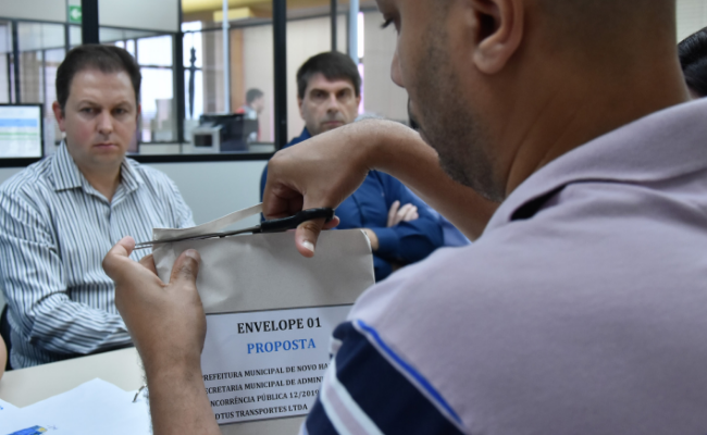Homem abrindo um envelope com uma tesoura