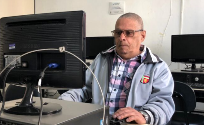 Homem sentado em frente a um computador