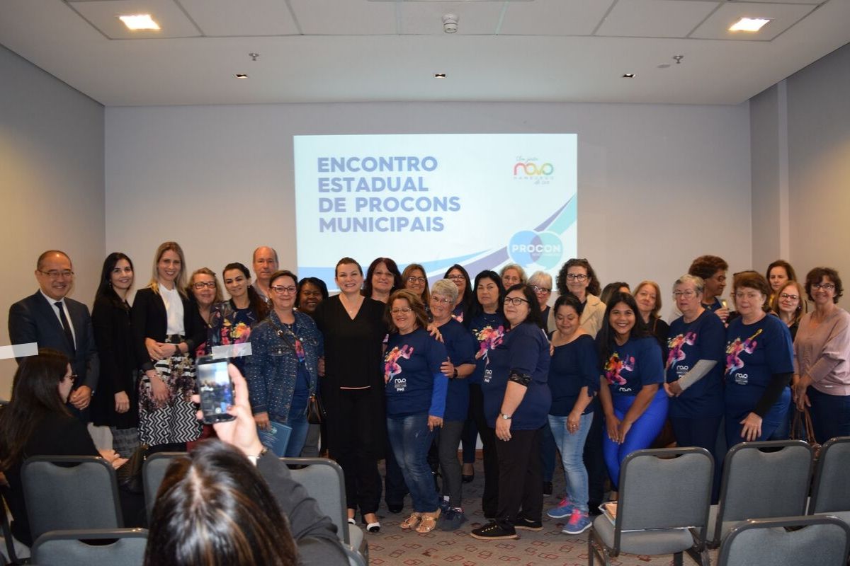 Grupo de mulheres abraçadas no fundo de uma sala