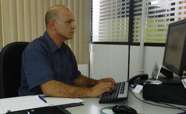 Homem sentado em frente a um computador