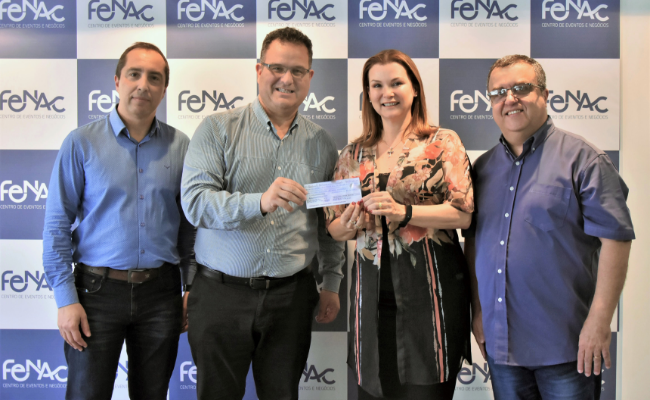 Três homens e a prefeita fátima em pé segurando um cheque