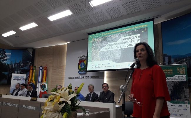 Secretária Paraskevi em pé ao microfone em um palco