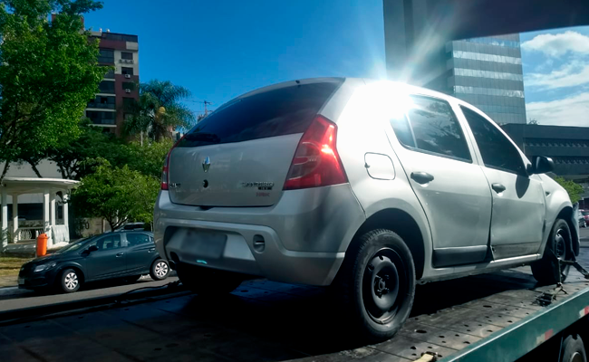 Carro em cima da plataforma de carregamento de um caminhão guincho