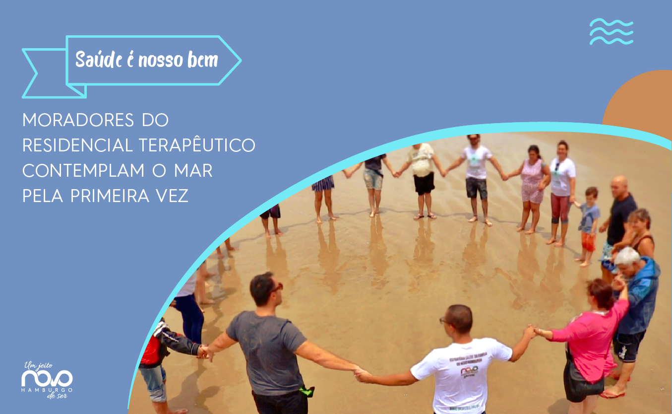 A imagem mostra um grupo de pessoas de mãos dados em círculo à beira do mar