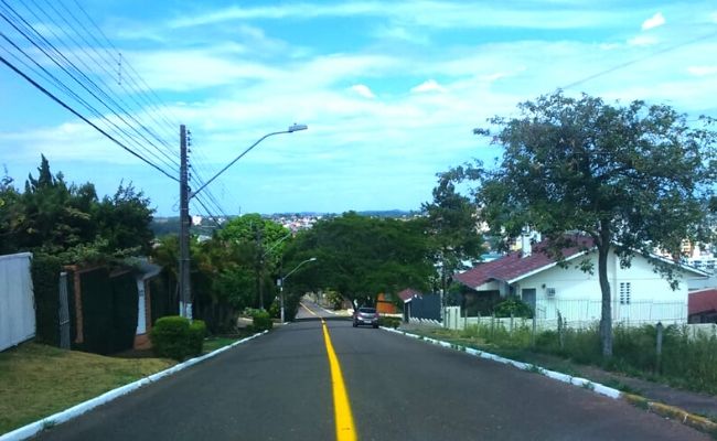 Imagem de uma rua de asfalto com a sinalização de trânsito central pintada