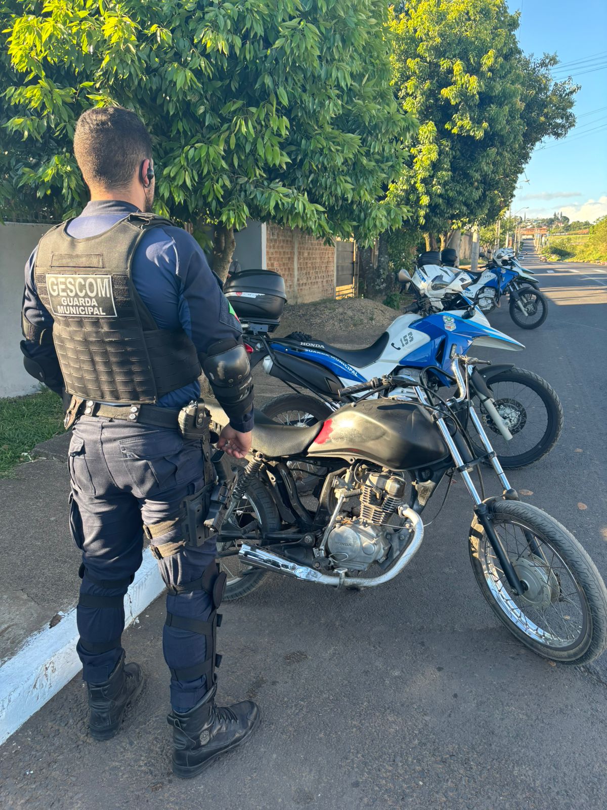 Guarda Municipal de costas com a moto recuperada