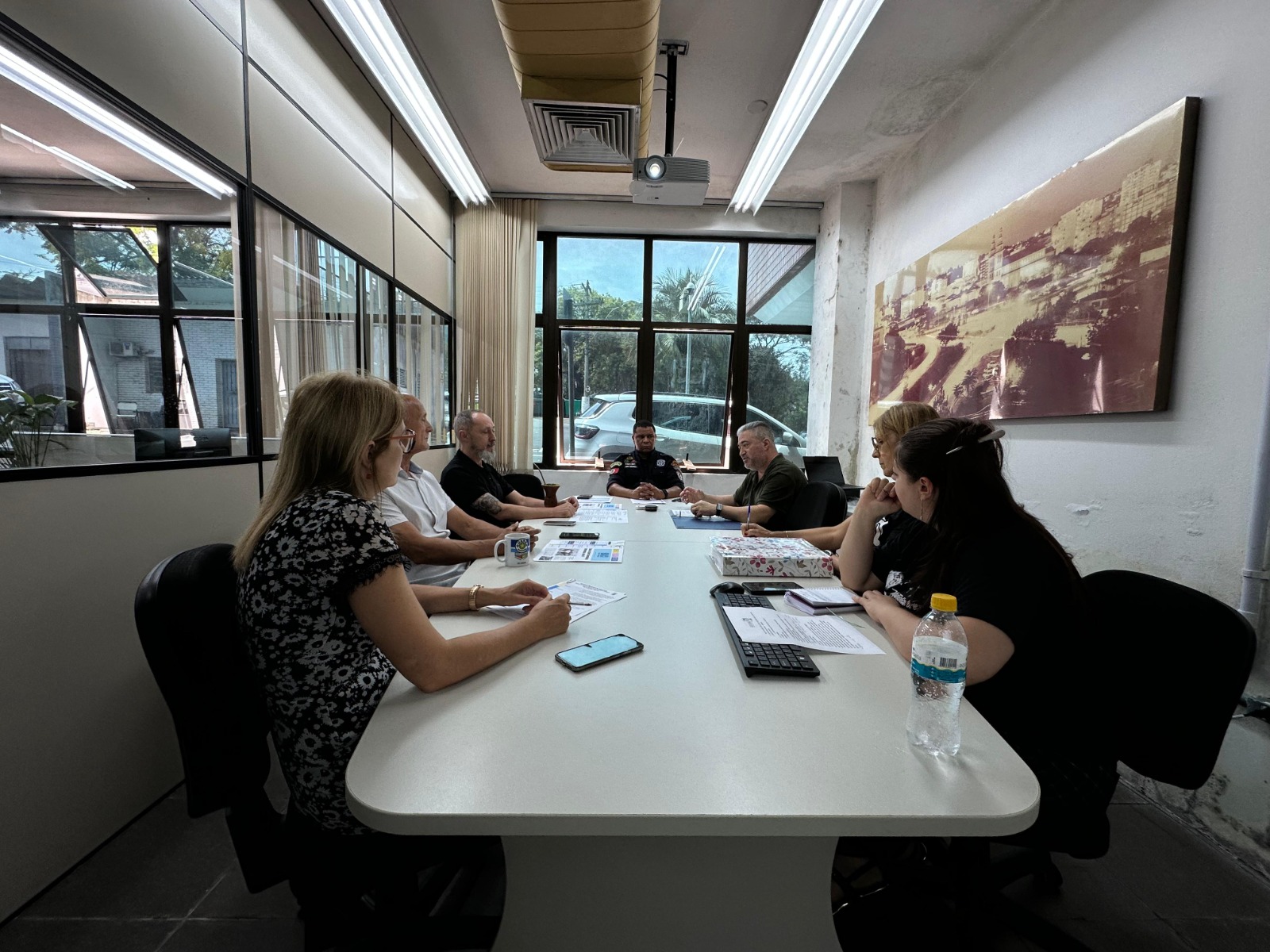 texto alternativo- equipe sentada ao redor de uma mesa conversando sobre as ações do programa